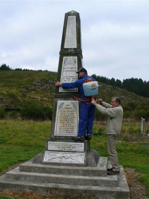 Waitaki Rotary Club member Brian Perkins scales the Georgetown war memorial with the help of...