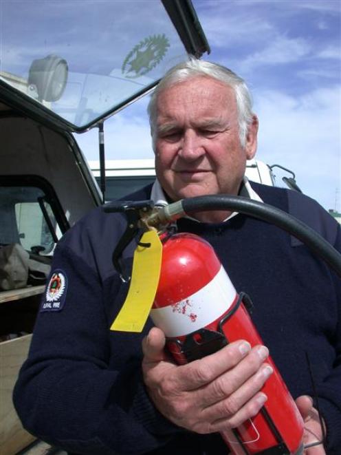Waitaki Rural Chief Fire Officer Eric Spittal checks the level of the fire extinguisher used at a...