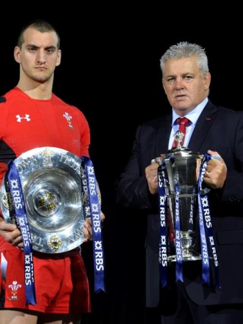 Wales captain Sam Warburton (L) poses holding the Six Nations trophy while coach Warren Gatland...