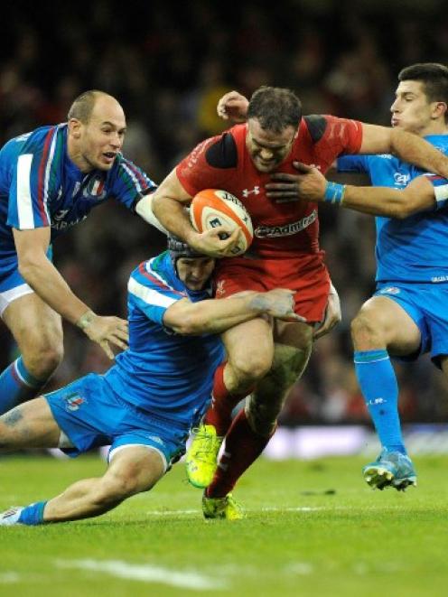 Wales' Jamie Roberts (C) is caught by the Italian defence. REUTERS/Rebecca Naden