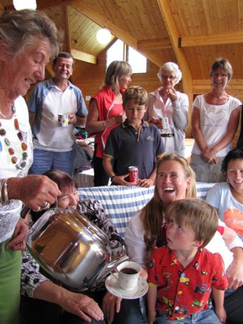Wanaka volunteer Nikki Heath centre, holding son Hunter (3), is poured a well earned cup of tea...