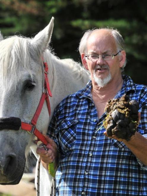 Wandering horseman Keith Roberts holds the manure of his horse Zara in Berwick. Photo by Linda...