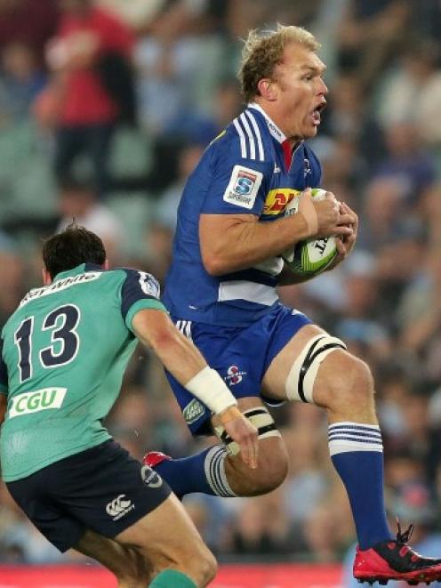 Waratahs centre Matthew Carraro bears down on an airborne Schalk Burger. Photo Getty Images