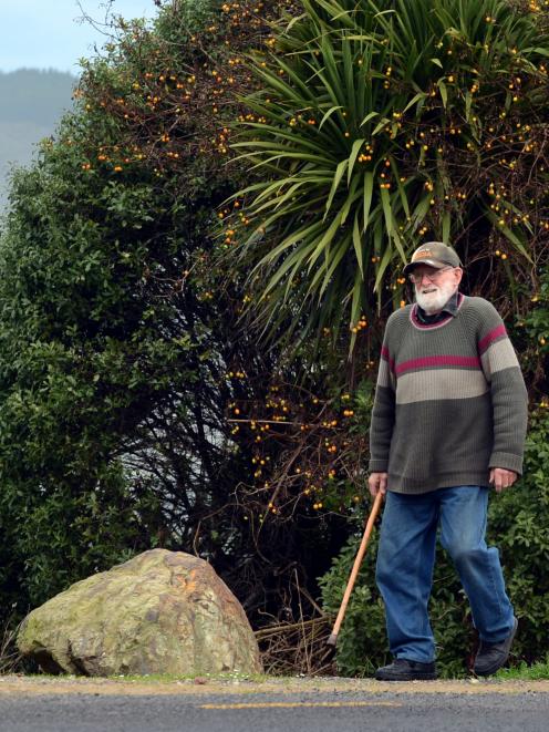 Warrington resident Dave Shanks and his dog Ollie pass  controversial rocks blocking vehicles...