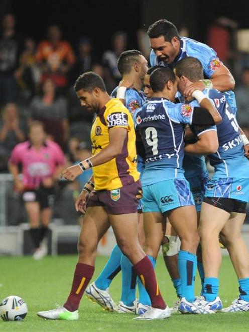 Warriors players celebrate a try during the pre-season game against the Brisbane Broncos at...