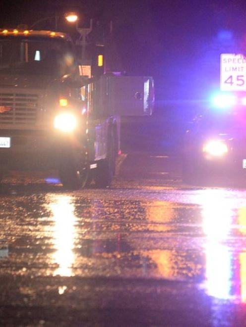 Water covers a street as a city worker walks by near a water main break that occurred in...