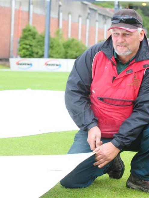 Wayne Walker, the new groundsman at Molyneux Park, adjust the covers at the University Oval...