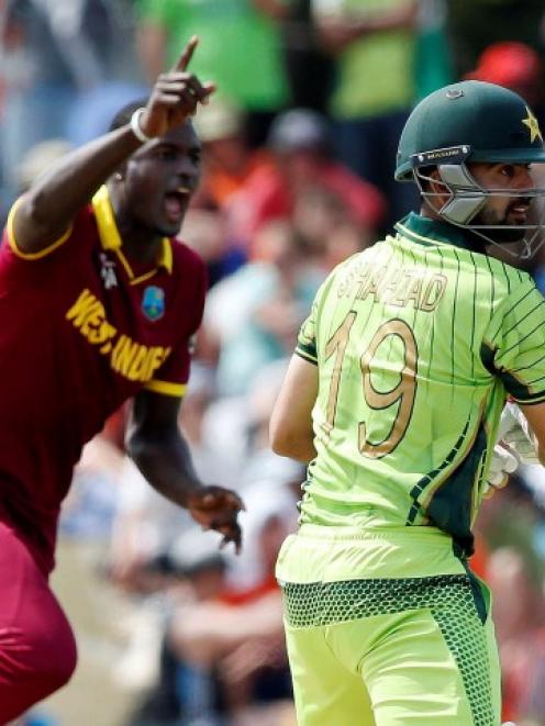 West Indies' Jason Holder celebrates dismissing Pakistan's Ahmed Shahzad (R) during their Cricket...