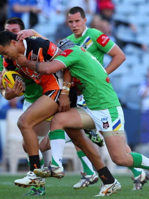 Wests Tigers' Mosese Fotuaika tries to break through the Canberra Raiders defence during the...