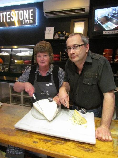 Whitestone Cheese employees Chris Thompson and Martyn Hall carve into a slab  of blue cheese....