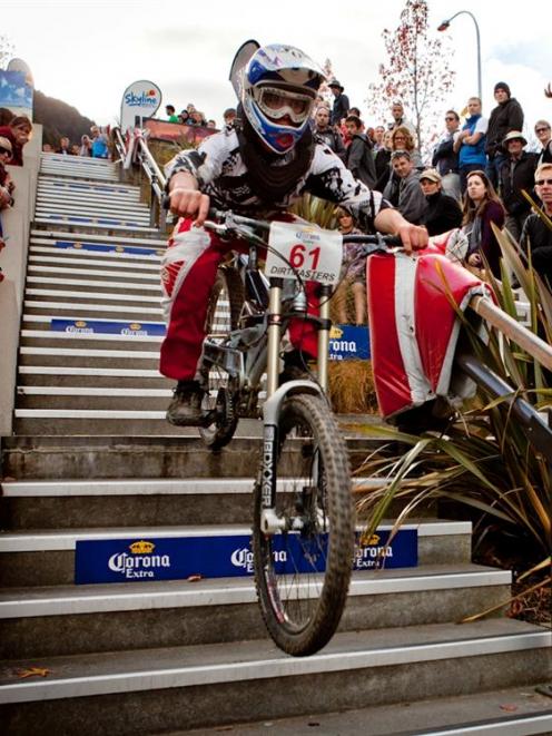 William Parata, of Karitane, bumps down the Brecon St stairs in the Queenstown Bike Festival...