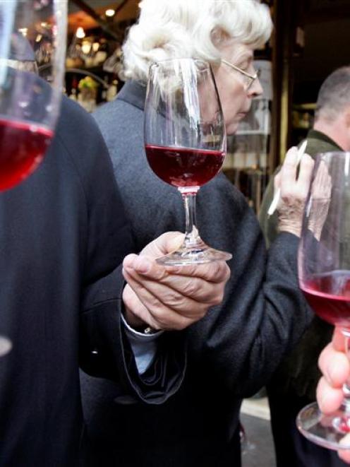 Wine lovers test the Beaujolais Nouveau at a wine dealer in Paris in this 2005 AP file photo.