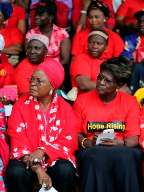 Women wearing red gather for a prayer vigil for the release of abducted secondary school girls in...