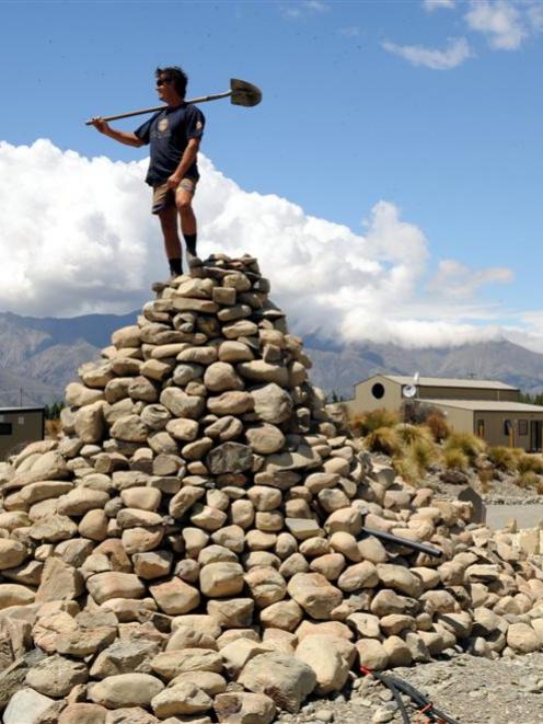 Worker Frank De Lorenzo stands on a stone cairn, reminiscent of Lindis Pass rock piles, at the...