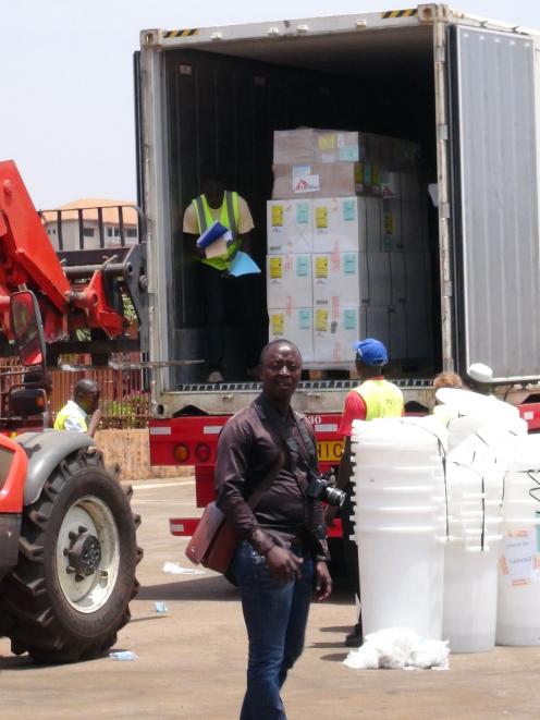 Workers from Doctors Without Borders unload emergency medical supplies to deal with an Ebola...