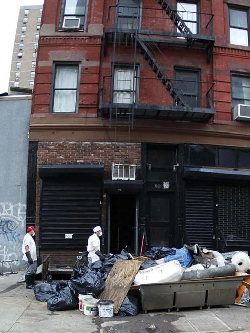 Workers load a bin with debris in the aftermath of Hurricane Sandy in New York.  REUTERS/Carlo...