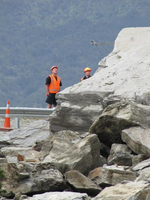 Workers survey the extent of the rockfall on State Highway 6 near Makarora this morning. Photo...