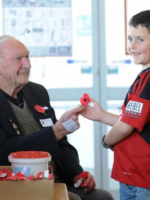 World War 2 veteran Theo Gray (85) sells a poppy to Charlie Gilbert (8), of Oamaru, on Thursday....