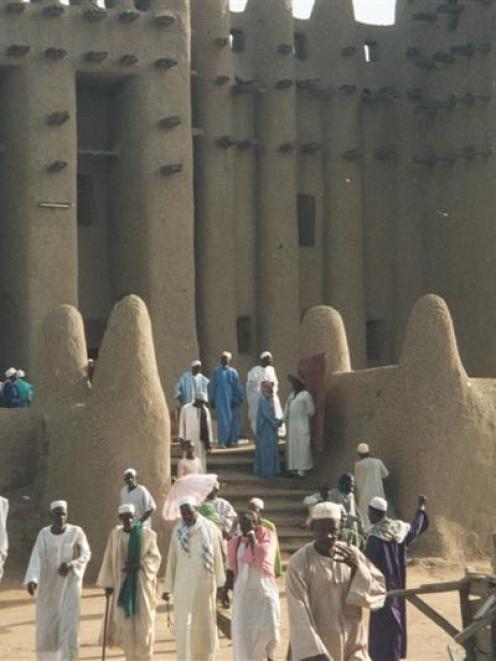 Worshippers (left) stream out of the grand mosque at Djenne. Photo by Alistair McMurran.
