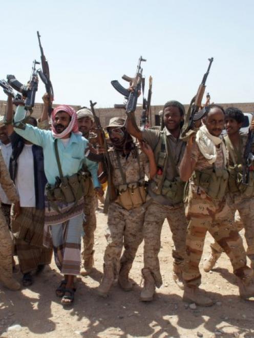 Yemeni soldiers hold up their weapons at a position taken from al Qaeda militants in Mayfaa, in...