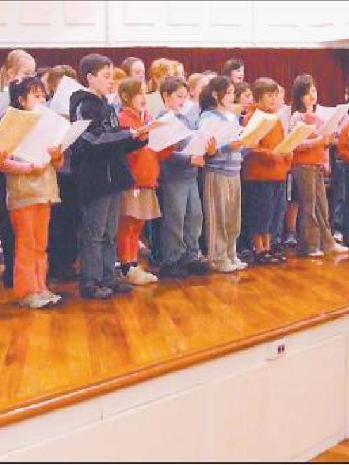 Young voices: Choir master David Burchell puts the children’s chorus through its paces during...