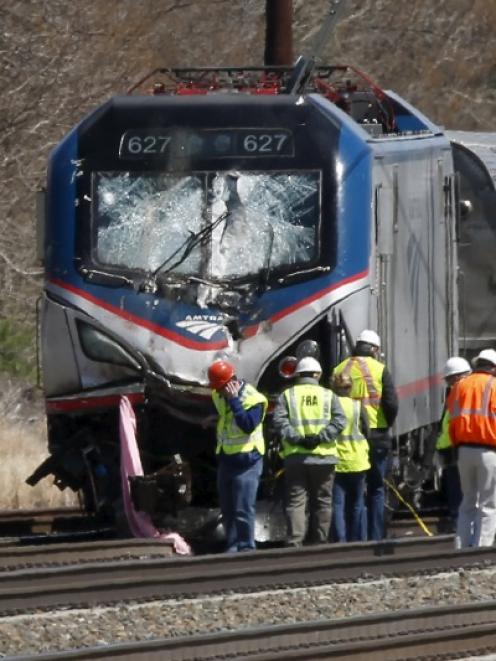 Emergency workers examine the scene where the train derailed. Photo: Reuters