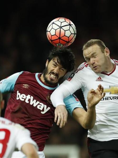 Manchester United's Wayne Rooney (R) vies for the ball with West Ham's James Tomkins. Photo Reuters