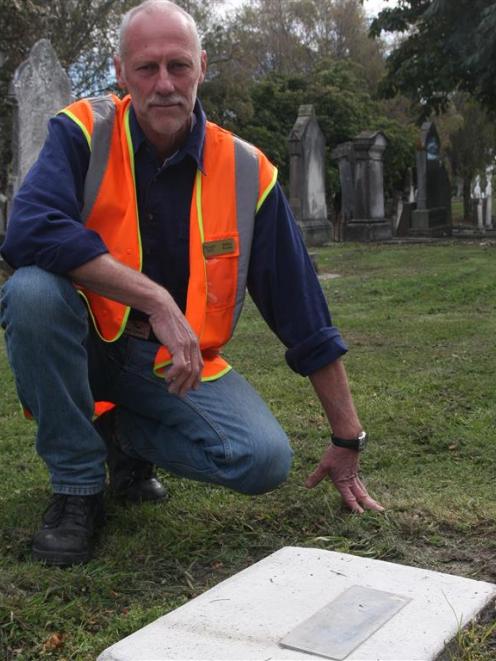 Waitaki District Council parks officer Mike Kwant inspects a grave from which the headstone was...