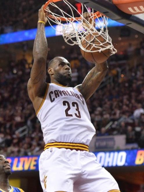 Cleveland's LeBron James dunks the ball in front of Golden State's Draymond Green during the...