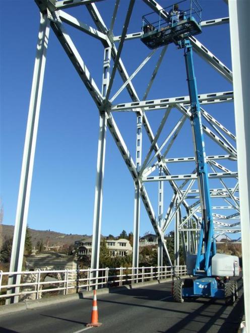 A Fulton Hogan worker cleans pigeon droppings off the Alexandra bridge yesterday  as part of...