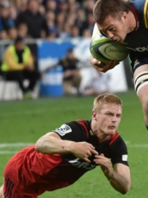 Highlanders replacement loose forward Liam Squire gets past Crusaders winger Johnny McNicholl to...