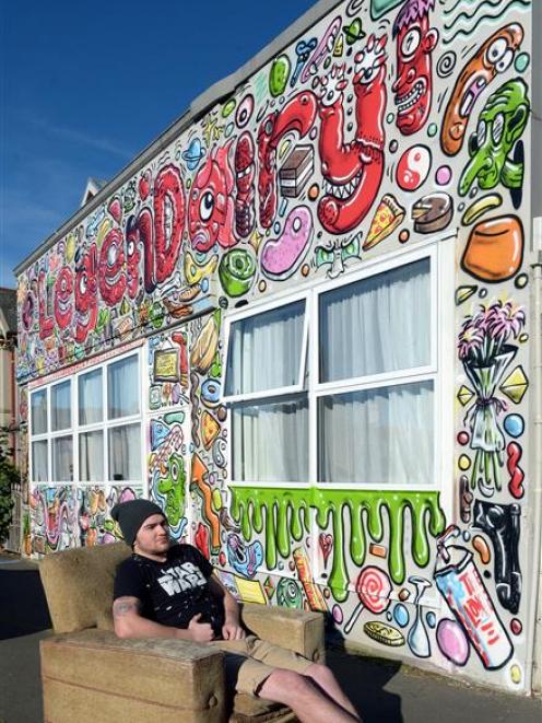 University of Otago student Nathan Laurie sits in front of his freshly painted Duke St flat....