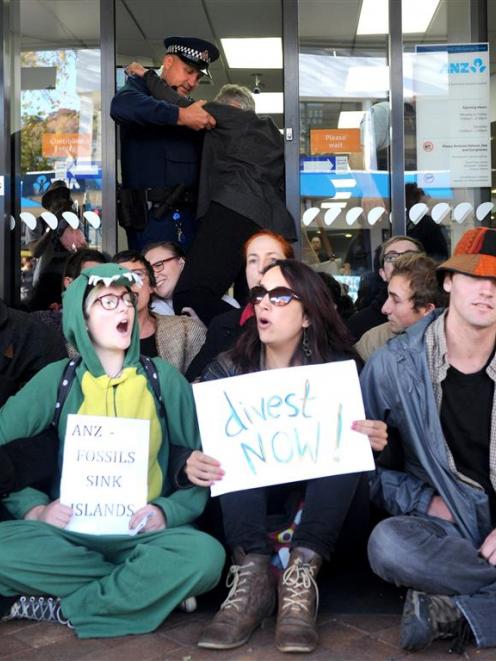 Police help a customer at the ANZ bank in Moray Place, during a recent fossil fuel protest. PHOTO...