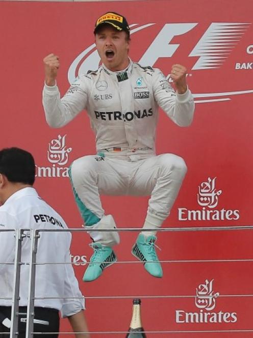 Nico Rosberg (C) celebrates his victory next to second-placed Sebastian Vettel (L) and third...