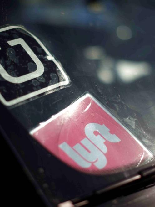 A driver displays Uber and Lyft ride sharing signs on his windscreen in Santa Monica, California....