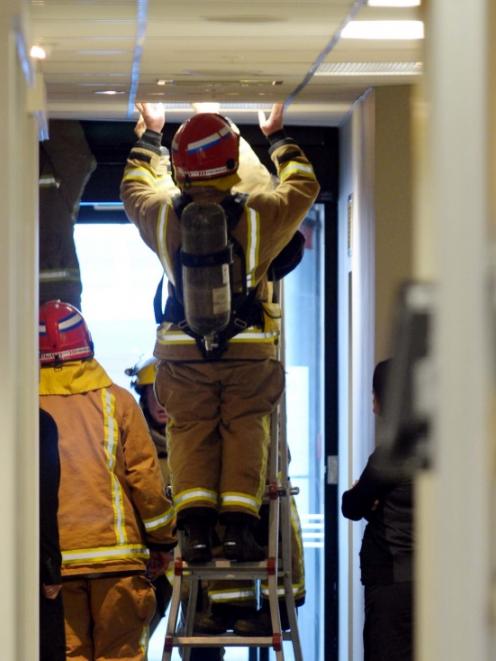 Firefighters check a light fitting at ASB Bank. Photo: Gerard O'Brien