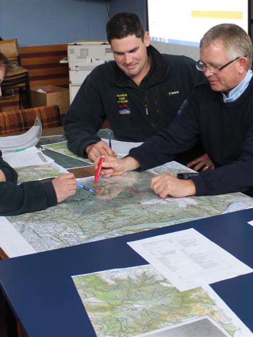LandSAR members Cheryl Pullar and Clem Munro with Senior Constable Murray Hewitson go over maps...