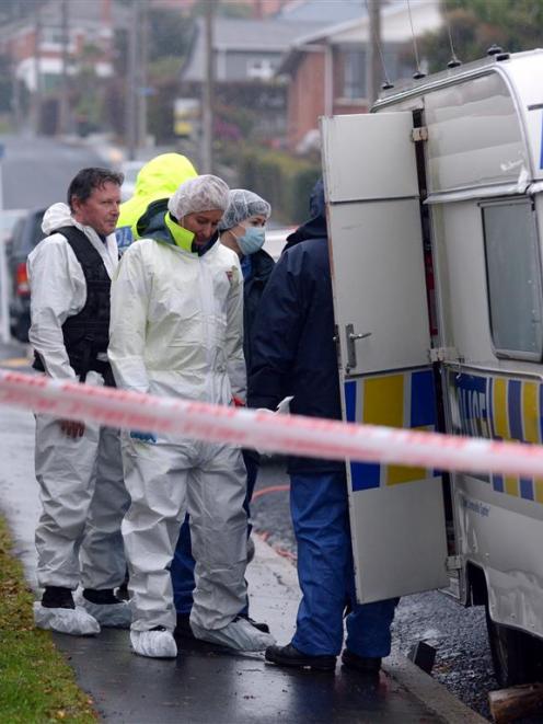 Scene of crime officers prepare to enter the Church St property yesterday. Photo by Gerard O'Brien.