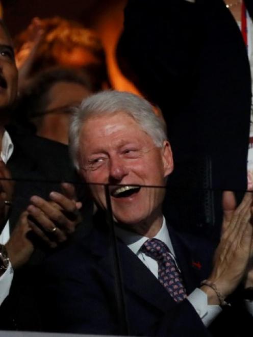 Bill Clinton applauds the speech by first lady Michelle Obama at the Democratic National...