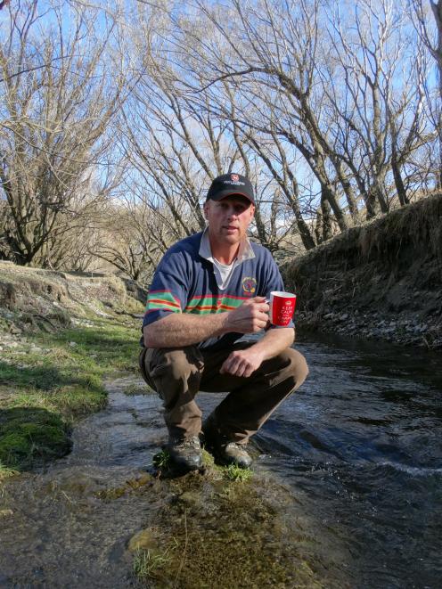 Spotts Creek Station owner Hamish Mackay drinks water from Spotts Creek. Photo: Mark Price.