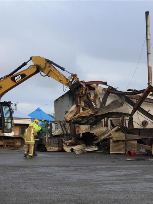 Fire investigators Mike Cahill (in yellow and blue jacket) and Cathy Trevathan working at the...