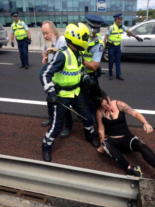 A police officer  grabs  Olive McRae, of Dunedin, by the hair to remove her from an Auckland...