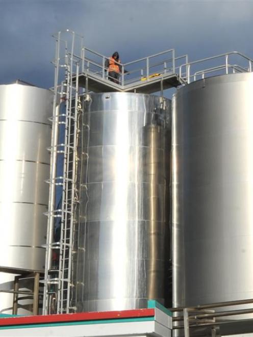A contractor stands on top of the silo as workers abseil inside.