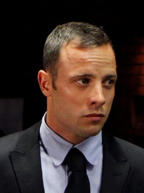 Oscar Pistorius stands in the dock during a break in court proceedings at the Pretoria...