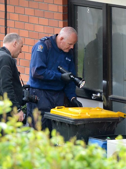 Police examine the property from which five rifles, 23 handguns and ammunition were stolen last...