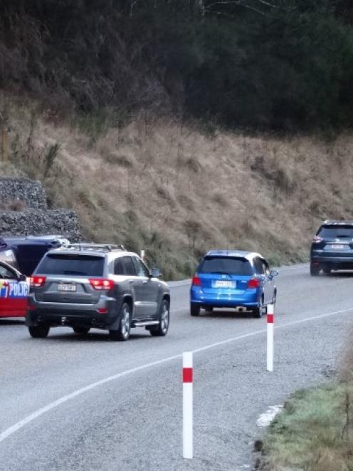 Cars on Queenstown's Gorge Rd, near Industrial Pl, snake past a car that crashed in icy...