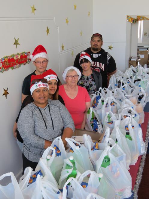 Volunteers with the Dunedin Combined Christmas Foodbanks pause for breath after packing up 320...
