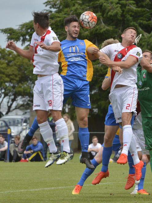 Eric Molloy (centre), of Southern United, heads the ball between Waitakere United players Ryan...
