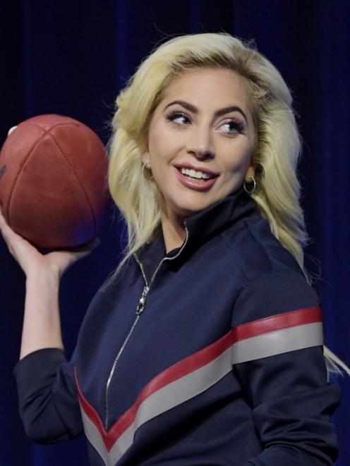 Lady Gaga poses with a football during the Super Bowl LI halftime show press conference in...