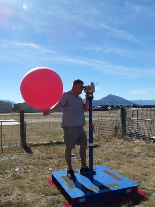 Nasa meteorologist Chris Schwantes checks wind speed and direction before releasing a pilot...